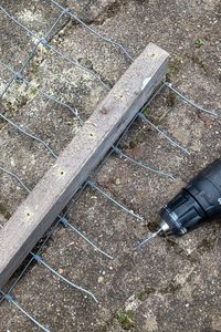 Gaten boren in de lat, op de hoogte van de gaasdraad.